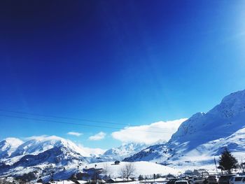 Scenic view of snowcapped mountains against blue sky