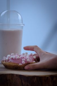 Close-up of hand holding ice cream on table