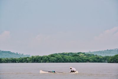 Men in boat against sky