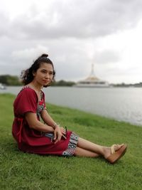  woman looking away sitting by lake