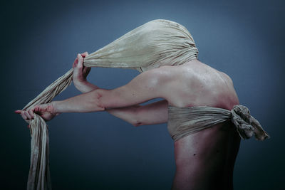 Rear view of shirtless woman against gray background