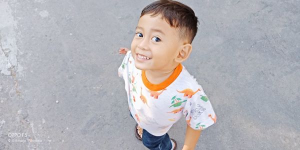 High angle portrait of cute boy standing on street