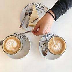 High angle view of woman holding coffee cup on table