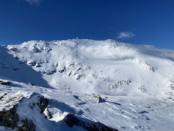 Scenic view of snowcapped mountains against blue sky