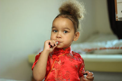 Close-up of cute girl applying lipstick