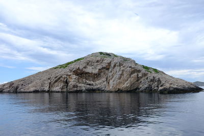 Scenic view of sea and rock formation against sky