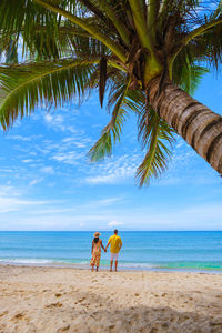 People at beach against sky