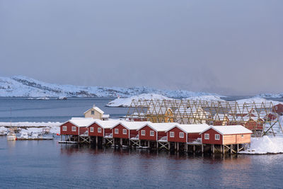 Houses by building against sky during winter