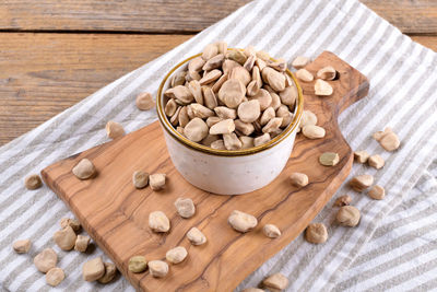 Cicerchia or indian pea on a ceramic bowl with napkin on natural wooden background, gluten free food