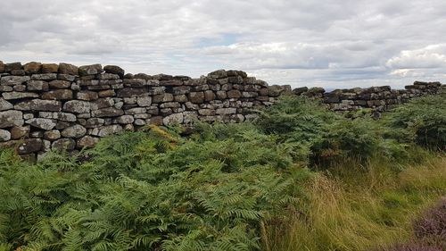 Stack of rocks on landscape against sky