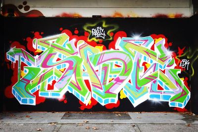 Graffiti on illuminated wall at night