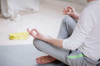 Low section of man doing yoga in studio