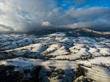 Aerial view of snowcapped mountains against sky