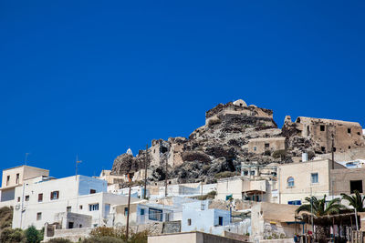 Low angle view of buildings against clear blue sky