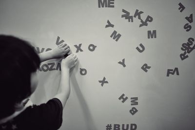 Girl playing with alphabets against wall