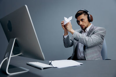 Businessman wearing wireless headphones working at desk
