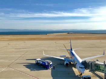 Airplane on airport runway against sky