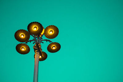 Low angle view of illuminated street light against blue sky