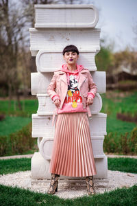 Portrait of smiling woman standing against plants