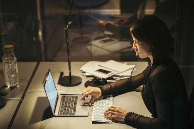 Side view of woman using mobile phone