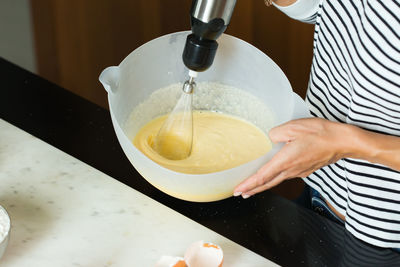 Woman kneading the dough while cooking apple pie in the modern kitchen