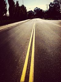 Empty road along trees