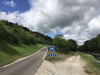 Road amidst trees against sky