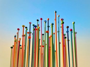 Low angle view of multi colored flags against clear blue sky