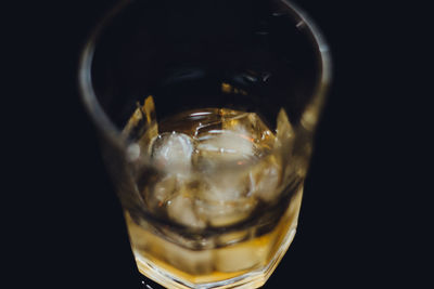 Close-up of beer glass against black background