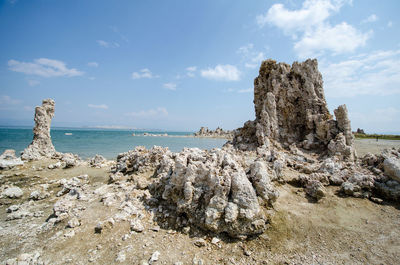 Rock formation on beach against sky