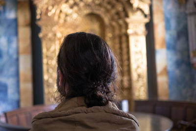 Rear view of woman in front of building