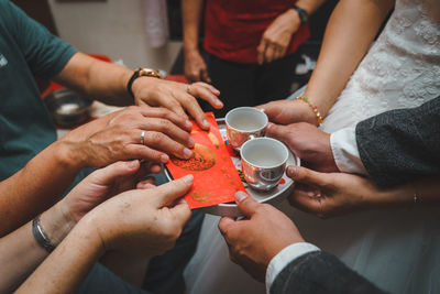 Midsection of people holding drink