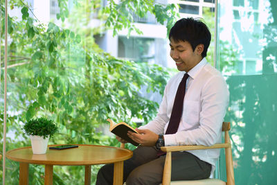 Businessman reading book at table in office