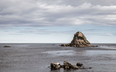 Scenic view of rock formation in sea against sky