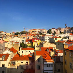 Houses in city against clear blue sky