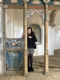 Portrait of woman standing against building