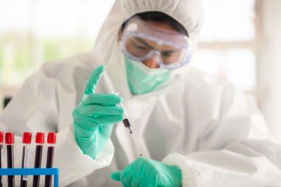 Smiling doctor wearing protective mask standing in laboratory