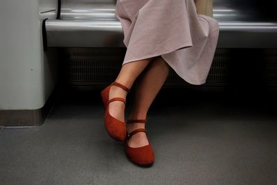 Low section of woman sitting on bench