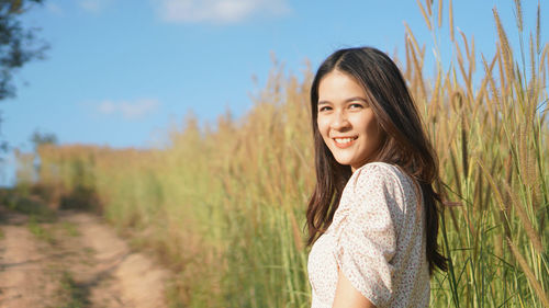 Portrait of smiling young woman on field