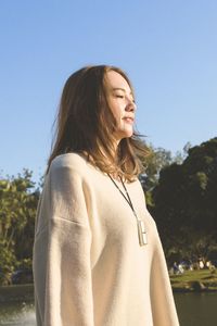 Young woman standing against clear sky