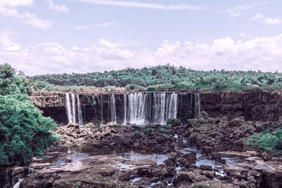 Scenic view of waterfall against sky