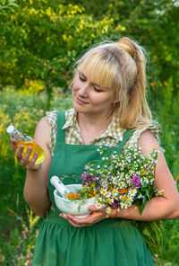 Portrait of smiling young woman holding bouquet