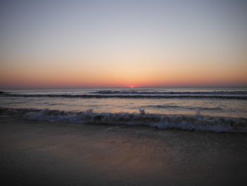 Scenic view of sea against clear sky at sunset