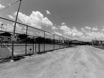 Empty road amidst buildings against sky