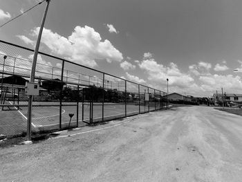 Empty road amidst buildings against sky