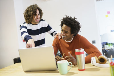 Young couple looking at camera while sitting on table