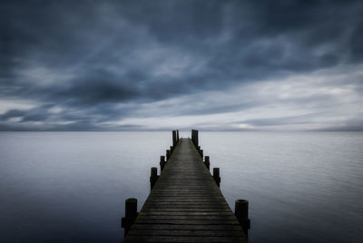 Boardwalk by the sea and a dramatic sky. 