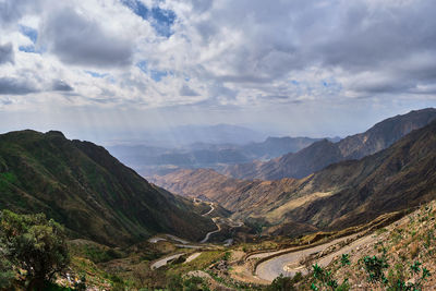 Scenic view of mountain range against cloudy sky