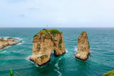 Rock formations in sea against sky