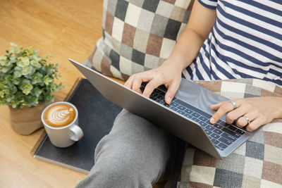 High angle view of man holding coffee cup on table